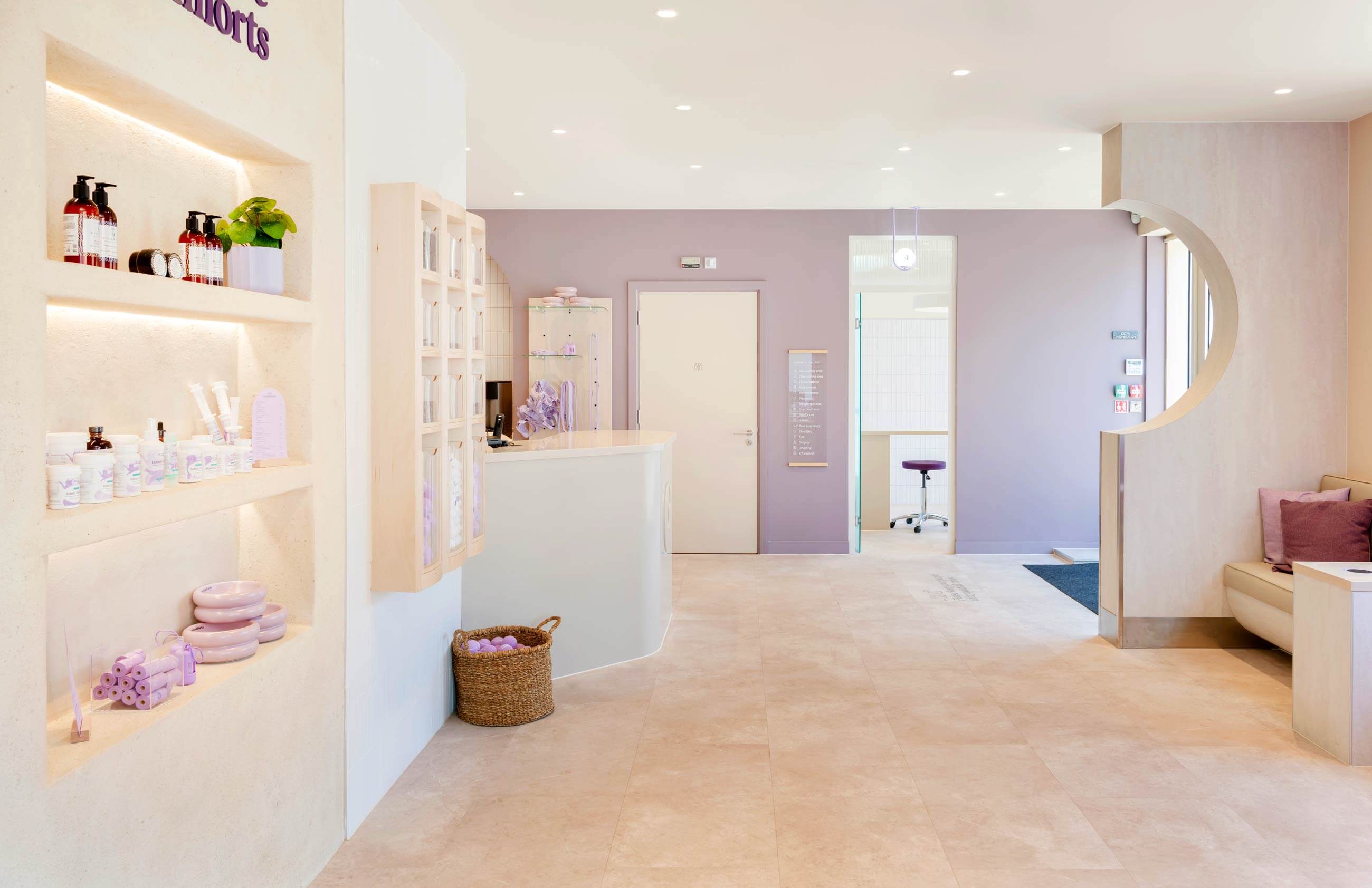 Bright, modern reception area with pastel tones, pet treat shelves, and a cozy seating area.